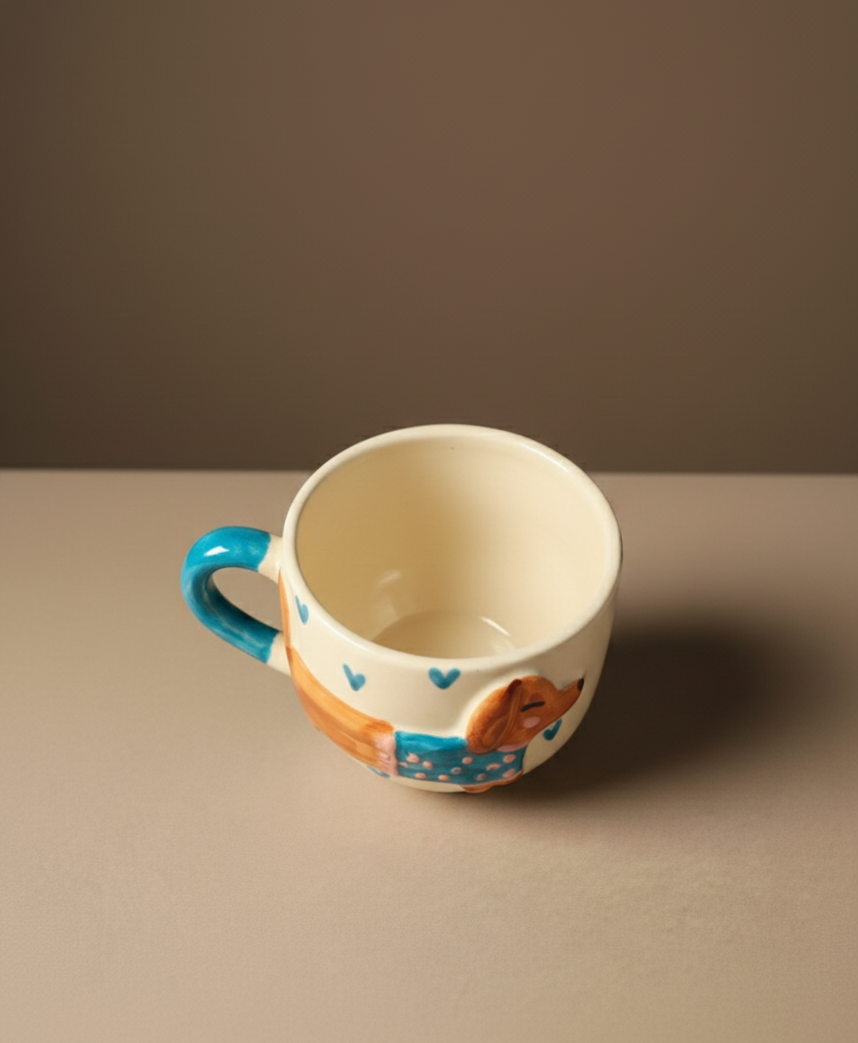 Ceramic mug with a blue handle and colorful design on a brown background