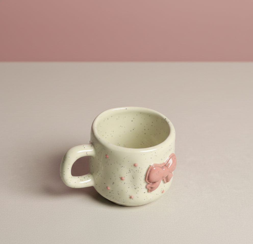 Speckled ceramic mug with a pink pig design on a beige background, perfect for gifting