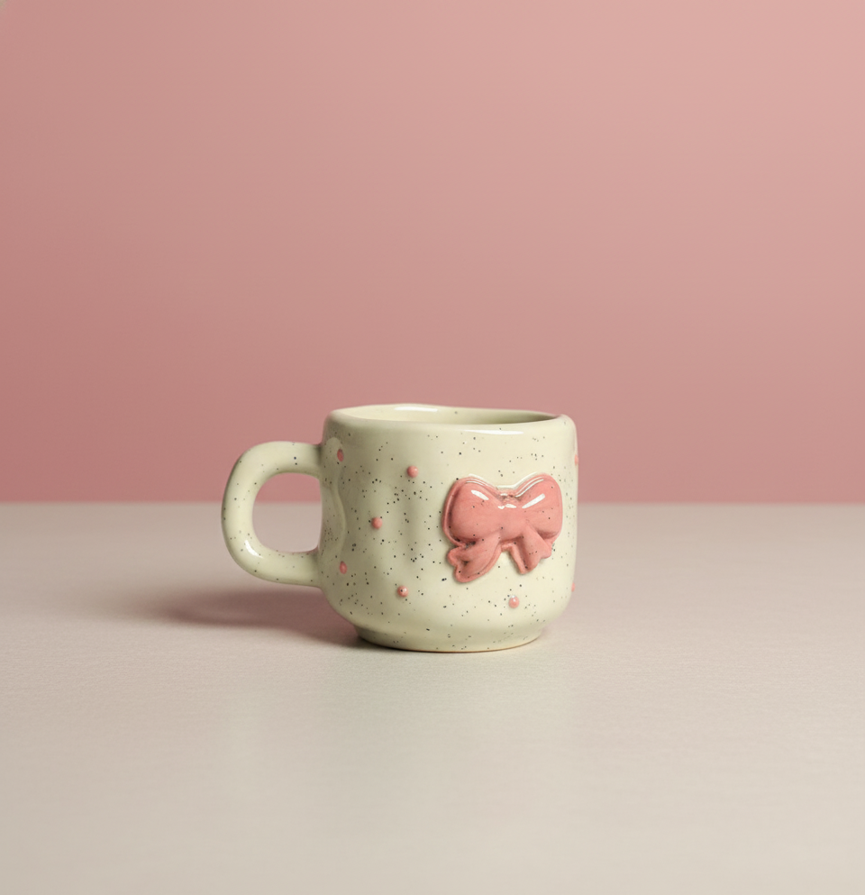 Cure Ceramic mug with a pink bow on a beige background